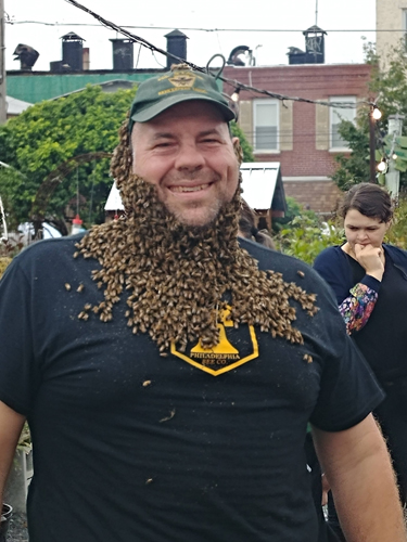 Photograph of Bee Keeper Don Shump, the founder of the Philadelphia Bee Company with a bee beard