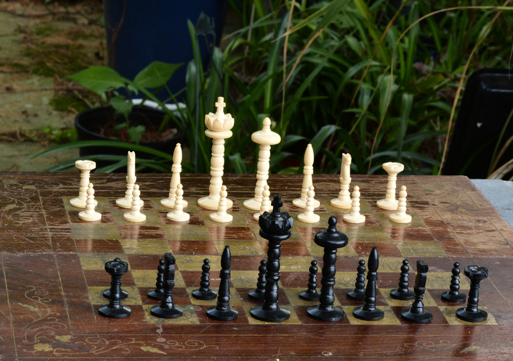 Photograph of a chessboard set up in a garden