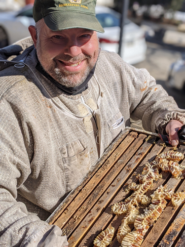 Don Shump, the founder of the Philadelphia Bee Company carrying honney comb frames