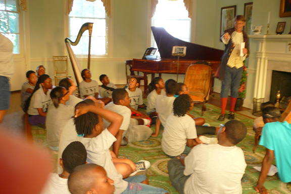 PHOTO OF TYSON GARDNER, PHILADELPHIA FAIRMOUNT PARK GUIDE, WITH A SUMMER CAMP GROUP