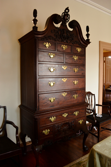 Candel light and apples create a charming image framed by a mahogany highboy